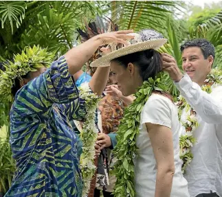  ?? PHOTO: MICHAEL CRAIG/POOL ?? A hat is placed on Prime Minister Jacinda Ardern as she enters Atapare Marae in the Cook Islands.