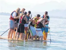  ?? FOTO: MS ?? Die Schüler stärken sich als Team beim Bau eines Floßes am See.