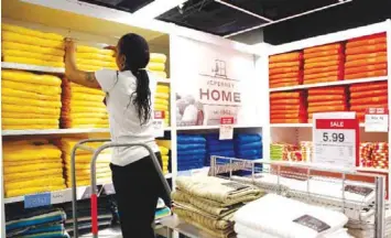  ?? — AP ?? NEW YORK: In this March 10, 2016 file photo, a sales clerk arranges towels that are part of a “Buy One Get One for a Penny” sale at a JC Penney store, in New York.