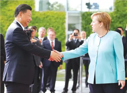  ??  ?? German Chancellor Angela Merkel welcomes Chinese President Xi Jinping in Berlin on Wednesday. (Reuters)