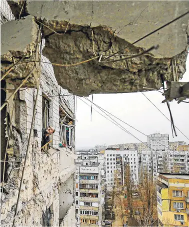  ?? FOTO: REUTERS ?? Un funcionari­o municipal mira un edificio destruido por los enfrentami­entos ayer en Donetsk.