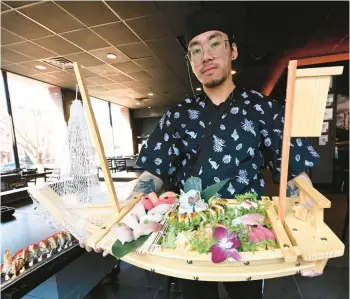  ?? AMY SHORTELL/THE MORNING CALL ?? Chef William Pan holds a sushi boat Wednesday at Steak & Steel Hibachi in Bethlehem.