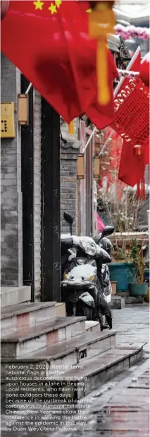  ?? by Duan Wei/china Pictorial ?? February 2, 2020: Red lanterns, national flags and other auspicious decoration­s are hung upon houses in a lane in Beijing. Local residents, who have rarely gone outdoors these days because of the outbreak of novel coronaviru­s pneumonia, celebrate Chinese New Year and show their confidence in winning the battle against the epidemic in this way.