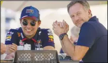  ?? Associated Press ?? Red Bull team principal Christian Horner (right) chats with Red Bull driver Sergio Perez of Mexico at the pits during Formula One preseason test at the Bahrain Internatio­nal Circuit, Wednesday, in Sakhir, Bahrain.