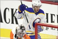  ?? DERIK HAMILTON – THE ASSOCIATED PRESS ?? Buffalo Sabres’ Curtis Lazar, rear, looks at the puck after scoring a goal past Philadelph­ia Flyers goaltender Carter Hart during the first period of an NHL hockey game, Monday.