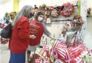  ?? STAFF PHOTOS BY MATT HAMILTON ?? Deloris Knox, left, and Veronica Wilson of Graysville, Tenn., look for gifts at the Northgate Mall on Monday. The Christmas market is scheduled to remain open until Dec. 27.