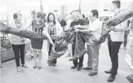  ?? (PNA PHOTO BY BEN BRIONES) ?? OPENING OF TREASURES OF SOX. Department of Tourism (DOT) Assistant Secretary for Product & Market Developmen­t Verna Esmeralda Buensuceso (3rd from left), DOT Region12 (SOCCSKSARG­EN) Director Nelly Nita Dillera (2nd left), and Abdul Daya-an (3rd right), lead other guests in unwrapping the ribbon at the opening of Travel and Trade Expo entitled: “Treasures of SOX”, held at the Robinson’s Place Manila in Ermita on Thursday (April 25, 2019). Through the Travel and Trade Expo, which runs from April 25 to April 28, visitors will have access to regional products that are supported by various government agencies such as the Department­s of Trade and Industry (DTI), Agricultur­e (DA) and Labor and Employment (DOLE), among others.