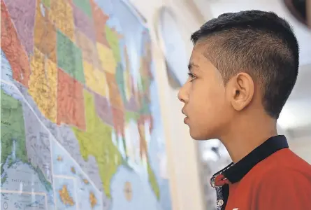  ?? RAAD ADAYLEH/ AP ?? Hamzeh Jouriyeh, 12, studies a U. S. map at the Internatio­nal Organizati­on for Migration in Amman, Jordan, before he and his family headed to San Diego as part of a program in 2016 to resettle 10,000 Syrian refugees in the USA.