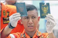  ?? AP PHOTO ?? A rescuer shows passports recovered from the area where a Lion Air plane crashed, at Tanjung Priok Port in Jakarta, Indonesia, Tuesday.