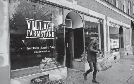  ?? [CHRIS SWEDA/CHICAGO TRIBUNE VIA TRIBUNE NEWS SERVICE] ?? A customer leaves Village Farmstand after a pick-up on Oct. 23 in Evanston, Ill.