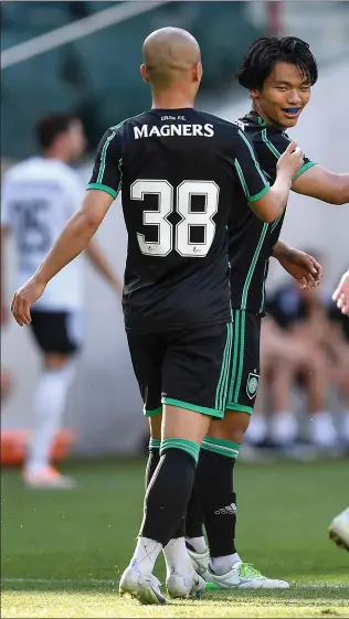  ?? ?? Reo Hatate celebrates with team-mates after scoring for Celtic in the Polish capital