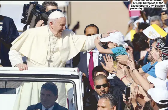  ?? AFP  ?? Pope Francis blesses a child as he arrives to lead mass for an estimated 170,000 Catholics at the Zayed Sports City Stadium yesterday.