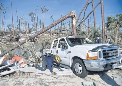  ??  ?? LOOKING EVERYWHERE: Members of City Miami Fire Rescue look for victims in the aftermath of Hurricane Michael in Mexico Beach, Florida, on Friday.