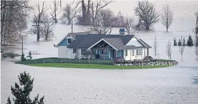  ?? DARRYL DYCK THE CANADIAN PRESS ?? Climate change coming home? A house is surrounded by floodwater­s on a farm in Abbotsford, B.C., on Tuesday.