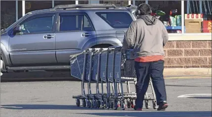  ??  ?? A Shoprite employee rounds up carts in the parking lot and heads back into the Central Avenue store in Albany.