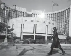  ?? REUTERS ?? A pedestrian walks past the headquarte­rs of the People’s Bank of China, the central bank, in Beijing on Feb 3.