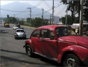  ??  ?? Drivers commute in their Volkswagen Beetles in a neighborho­od of Mexico City known colloquial­ly as “Vocholandi­a,” for its love of the classic Beetle, called “vocho” on Tuesday. AP PHOTO/CRISTINA BAUSSAN