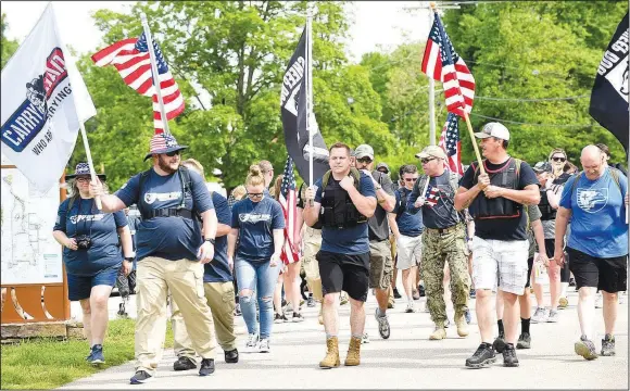  ?? (NWA Democrat-Gazette File Photo/Flip Putthoff) ?? Sheep Dog Impact Assistance members, including Michael Nimmo (center), begin the Carry the Load walk in May at Lake Bella Vista to remember fallen veterans over Memorial Day and every day of the year. SDIA will host an online “10th Anniversar­y Salute” on Aug. 25.