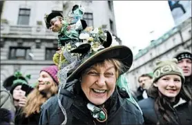  ?? CHARLES MCQUILLAN/GETTY ?? A wee bit Irish: A spectator shows off her hat Saturday at the annual Saint Patrick’s Day parade in Dublin. “Game of Thrones” actor Liam Cunningham was the grand marshal of Saturday's Irish parade, which was attended by Irish President Michael Higgins.