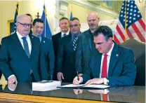  ?? SARAH PHIPPS/ASSOCIATED PRESS FILE PHOTO ?? Oklahoma Republican Gov. Kevin Stitt signs an executive order in the Blue Room at the state Capitol late last year in Oklahoma City. The executive order prohibits state agencies and universiti­es from spending money on diversity initiative­s.