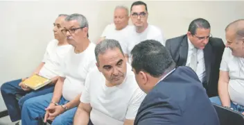  ??  ?? El ex presidente de El Salvador, Elías Antonio Saca (Centro), habla con su abogado mientras espera su sentencia.
