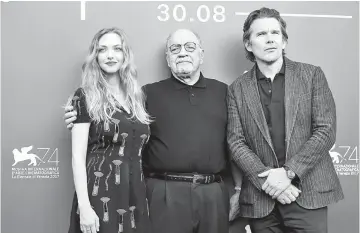  ??  ?? Director Schrader (centre) poses with Hawke and Seyfried during a photocall for ‘First Reformed’ at the Venice festival on Thursday. — Reuters photo