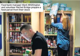  ??  ?? Food bank manager Mark Whittingto­n and volunteer Rachel Bridge prepare a food parcel from their stock