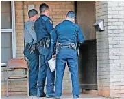  ??  ?? Oklahoma City police officers Joshua Gershon, left, Billy Robison and Eric Gengnagel talk with a resident in northeast Oklahoma City.