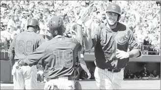  ??  ?? Cubs rookie Kris Bryant (right) celebrates with a teammate after hitting a home run in the third inning of a spring training game against the Oakland Athletics in Las Vegas. Bryant is expected to be in Chicago later this month.