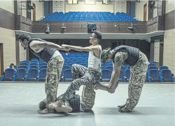  ?? ?? Taha al-Baskini, left, Mohammed Ben Nasser, bottom, and others rehearse for ‘When We Were Alive’, a play about soldiers who reunite after dying in combat, at the National Theater in Misrata, Libya.