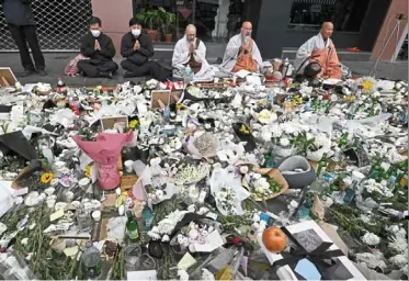  ?? — AFP ?? On a downturn: South Korean Buddhist monks pray at a makeshift memorial for the victims of the deadly Halloween crowd surge. Consumptio­n in the country is weakening after the October 2022 tragedy.