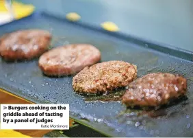  ?? Katie Mortimore ?? > Burgers cooking on the griddle ahead of tasting by a panel of judges