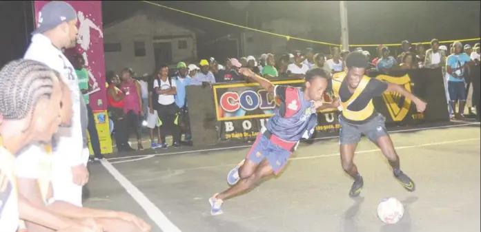  ??  ?? Hustlers Sunil Logan (right) tussling with a Bagotstown Ballers player for possession of the ball at the Pouderoyen Tarmac in the third annual Guinness ‘Greatest of the Streets’ West Demerara/East Bank Demerara zone Friday night. (Orlando Charles photo)