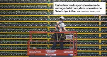  ?? PHOTO D’ARCHIVES, AFP ?? Un technicien inspecte le réseau de minage du bitcoin, dans une usine de Saint-Hyacinthe.