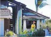  ?? K.C. ALFRED U-T ?? San Miguel Fire Capt. Bob Lundstrom looks over a home in Rancho San Diego that burned Wednesday.