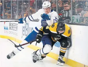  ?? WINSLOW TOWNSON THE ASSOCIATED PRESS ?? Toronto’s Jake Gardiner checks Boston Bruins’ Jake DeBrusk into the boards on Saturday. The Leafs’ overall defensive performanc­e has helped goalie Freddie Andersen excel under pressure.