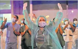  ?? Picture: AP ?? Health workers react to applause from people at the Jimenez Diaz Foundation University hospital in Madrid, Spain.