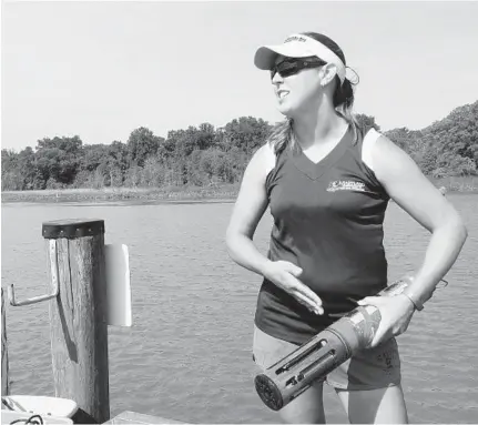  ??  ?? Research technician Stephanie Hall displays a piece of equipment that gathers climate data at Jug Bay Wetlands Sanctuary. More than a century’s worth of collected data has given researcher­s a picture of a gradually warmer and wetter Chesapeake Bay region.