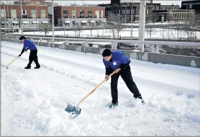  ?? MARLA BROSE/JOURNAL ?? LEFT: Clearing a ramp to the Albuquerqu­e Convention Center parking garage, Jason Terrell, right, and Brian Diemert work to move snow that fell Friday night and early Saturday.