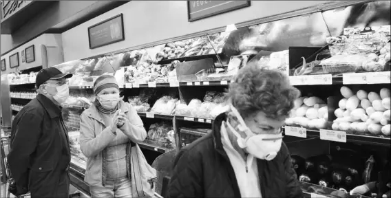  ?? AP PHOTO/RICHARD VOGEL ?? Customers wearing protective masked shop the fresh produce section at Gelson’s supermarke­t that opened special morning hours to serve seniors 60 years and older due to coronaviru­s concerns, on Friday, in the Sherman Oaks section of Los Angeles.