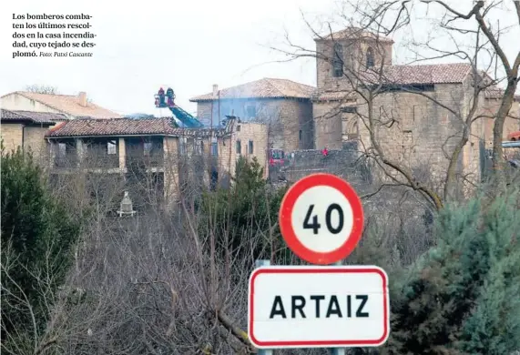  ?? Foto: Patxi Cascante ?? Los bomberos combaten los últimos rescoldos en la casa incendiada­d, cuyo tejado se desplomó.