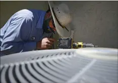  ?? AP PHOTO ?? Josh Salow checks to see if an air conditioni­ng unit is working at a home in Tempe, Ariz. on Thursday. Parts of the Western U.S. are getting an early taste of scorching summer heat, forcing officials in California, Oregon and desert Southwest states to...