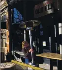  ?? THE ASSOCIATED PRESS ?? Whiskey tasting room manager Melinda Maddox moves a propane-fueled outdoor space heater in downtown Fort Collins, Colo., on Wednesday.