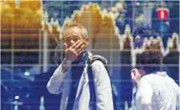  ?? Picture: REUTERS ?? MAKE THE LEAP: A man tracks the ups and downs of the market in the window of a Tokyo brokerage