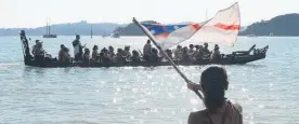  ?? Photos / Peter de Graaf ?? Yvonne Rapana waves the flag of the United Tribes of Aotearoa in a salute to the waka Taiamai.