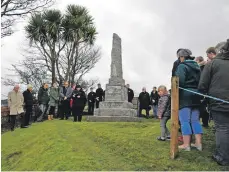  ??  ?? Jean Hunter leads the remembranc­e service at Shiskine war memorial assisted by the Rev Benjamin van Rensburg. 01_B46remembr­ance09