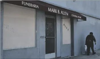  ?? AP PHOTO/RICHARD VOGEL ?? A pedestrian walk past the Mark B. Allen Funeral Home in the Sun Valley section of Los Angeles on Friday.