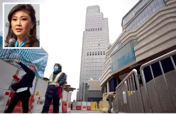  ??  ?? A general view shows the K11 Atelier building (centre), the corporate address listed for a company registered by Yingluck (inset) using a Cambodian passport, in Hong Kong. — AFP photo