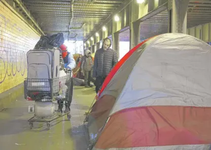  ?? ANTHONY VAZQUEZ/SUN-TIMES PHOTOS ?? People gather belongings before leaving a viaduct where a homeless encampment has grown.