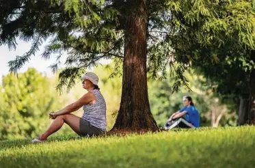  ?? Marie D. De Jesús / Staff photograph­er ?? Kim Kressenber­g sits under a tree Saturday as part of an inaugural mindfulnes­s and meditation class at Buffalo Bayou Park. Saturday’s practice was grounding to the earth through the trees, inspired by forest bathing movements in South Korea and Japan. Heather Sullivan, a mindfulnes­s instructor, led the lesson.